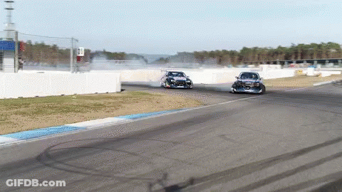 Two Cars Are Racing On A Race Track And One Of Them Has A Sticker On The Side That Says ' Toyota ' GIF