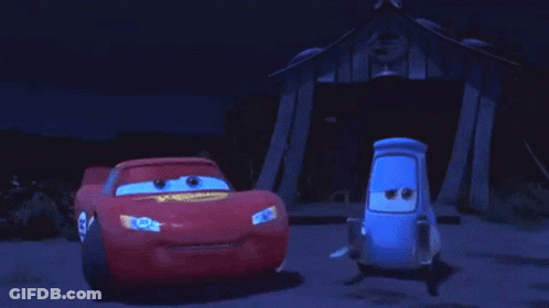 Two Cars Are Standing Next To Each Other In Front Of A Building At Night . GIF