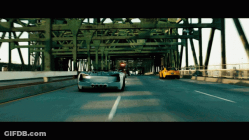 Two Cars Driving On Highway Under Bridge With Ambulance Sign GIF