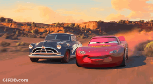 Two Cars From The Movie Cars Are Racing On A Road GIF