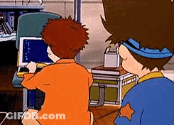 Two Cartoon Characters Are Sitting At A Table Looking At A Laptop Computer . GIF