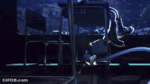 Two Cartoon Characters Are Standing Next To Each Other In A Dark Room . One Of The Characters Is Holding A Microphone . GIF