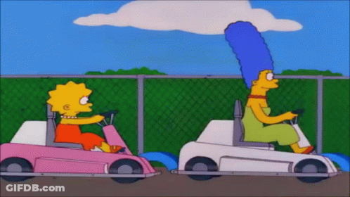 Two Cartoon Characters , Lisa Simpson And Marjorie Simpson , Are Riding Go Karts . GIF