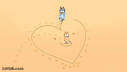 Two Cartoon Dogs Are Drawing A Heart In The Sand GIF