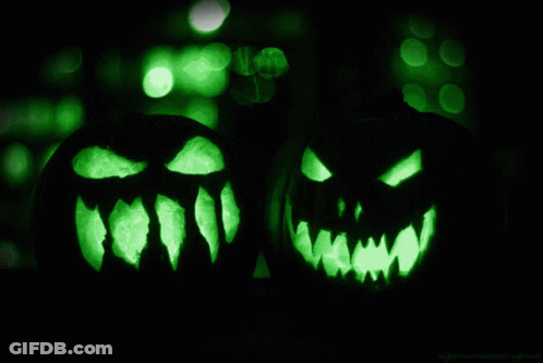 Two Carved Pumpkins With Glowing Faces In Dark GIF