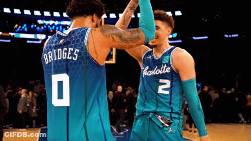 Two Charlotte Basketball Players High Five Each Other On The Court GIF