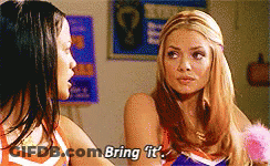Two Cheerleaders Are Talking To Each Other And One Of Them Is Saying Bring It GIF