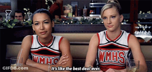 Two Cheerleaders From Wmhs Are Sitting Next To Each Other In A Diner GIF