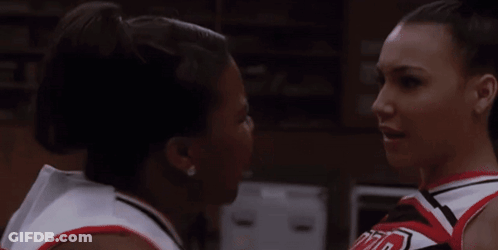 Two Cheerleaders Looking At Each Other, One In UCLA Shirt GIF