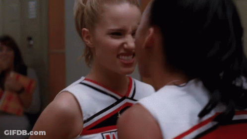 Two Cheerleaders Looking At Each Other, One Wearing Jersey Saying N GIF
