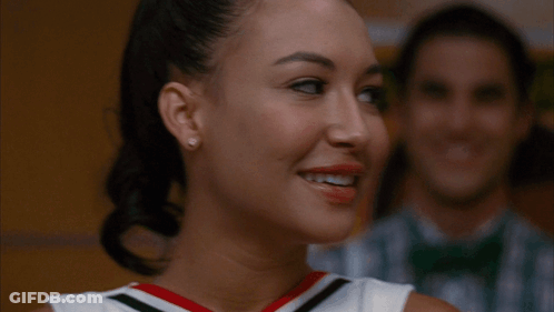 Two Cheerleaders Smiling In Front Of Man In Bow Tie GIF