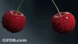 Two Cherries Are Falling Into The Water With Bubbles GIF