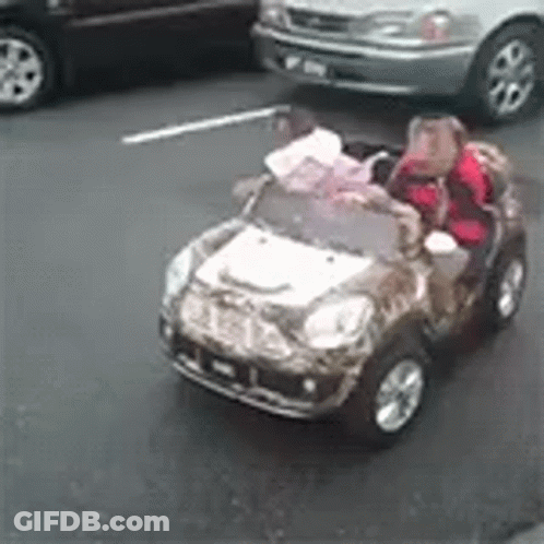 Two Children Are Riding In A Toy Car On The Street GIF