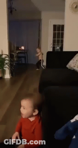 Two Children Playing In Living Room With Couch And Table GIF