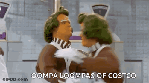 Two Chocolate Men Are Hugging Each Other In A Kitchen And The Words Oompa Loompas Of Costco Are Visible . GIF