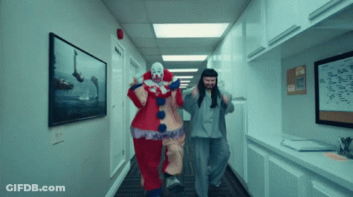 Two Clowns Are Running Down A Hallway With A Sign On The Wall That Says ' A ' GIF