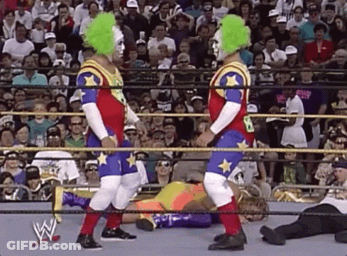 Two Clowns Are Standing In A Wrestling Ring . GIF