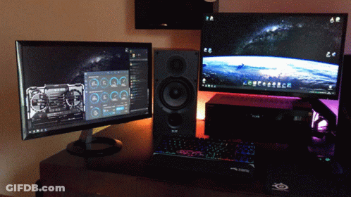 Two Computer Monitors And A Keyboard On A Desk With A Mouse Pad That Says ' Steelseries ' On It GIF