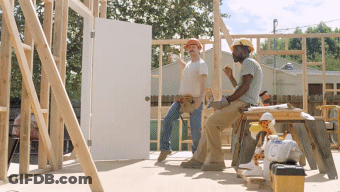 Two Construction Workers Are Having A Conversation While Sitting On A Stool GIF