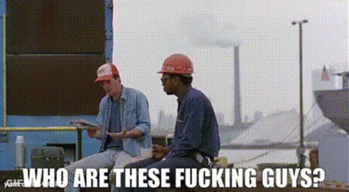 Two Construction Workers Are Sitting Next To Each Other In Front Of A Building . GIF