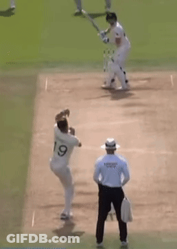 Two Cricket Players Are Playing A Game Of Cricket On A Field With A Referee Watching . GIF