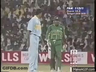 Two Cricket Players Are Talking To Each Other On A Field . GIF