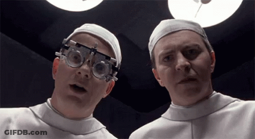Two Doctors In Surgical Caps And Goggles GIF