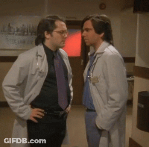 Two Doctors Shaking Hands By Emergency Room Sign GIF