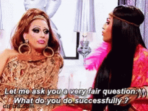 Two Drag Queens Are Sitting Next To Each Other And One Of Them Is Asking The Other A Question GIF