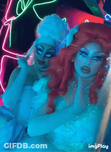 Two Drag Queens Posing With Neon Sign Saying Imgplay GIF