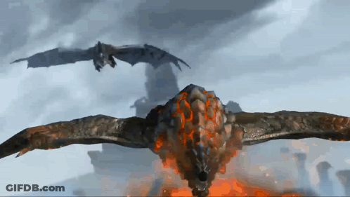 Two Dragons Are Flying In The Sky And One Of Them Is Covered In Fire GIF