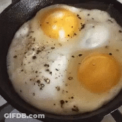 Two Eggs Being Cooked In A Pan GIF