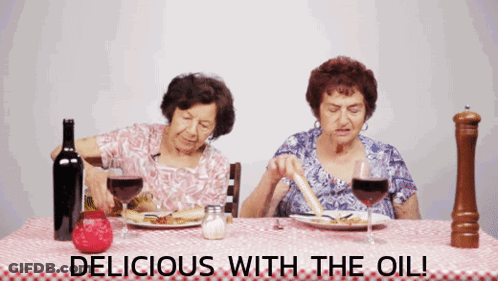 Two Elderly Women Sitting At A Table With The Words " Delicious With The Oil " GIF