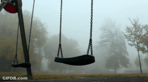 Two Empty Swings In A Foggy Park On A Cloudy Day GIF
