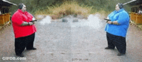 Two Fat Men Holding Guns In A Shooting Range GIF