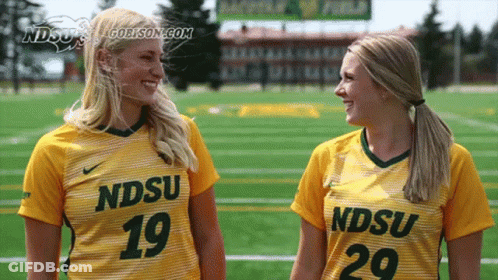 Two Female Athletes Wearing Yellow Jerseys With Ndsu On Them GIF