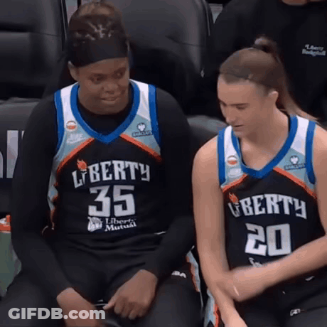 Two Female Basketball Players In Liberty Jerseys Sitting On Bench GIF