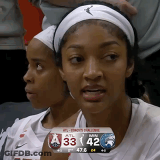 Two Female Basketball Players In Stands With Scoreboard 33-42 GIF