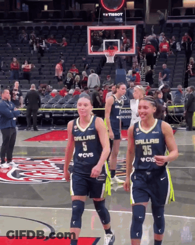 Two Female Basketball Players Wearing Dallas Jerseys Are Walking On The Court GIF