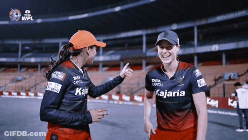 Two Female Cricket Players Wearing Shirts That Say Kajaria On Them GIF