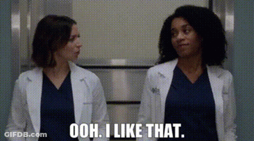 Two Female Doctors Are Standing Next To Each Other In A Hallway And One Of Them Is Talking . GIF