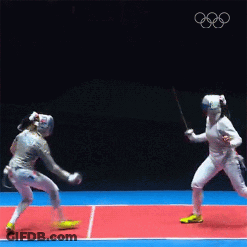 Two Female Fencers Are Fighting Each Other On A Court . GIF