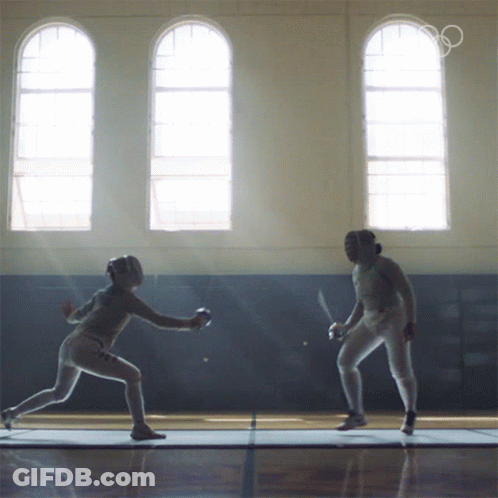 Two Female Fencers Are Fighting In A Gym With The Olympics Logo In The Background GIF