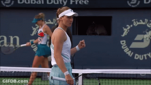 Two Female Tennis Players On A Court With A Dubai Duty Free Sign In The Background GIF