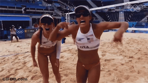 Two Female Volleyball Players From The Usa Are Standing On The Sand GIF