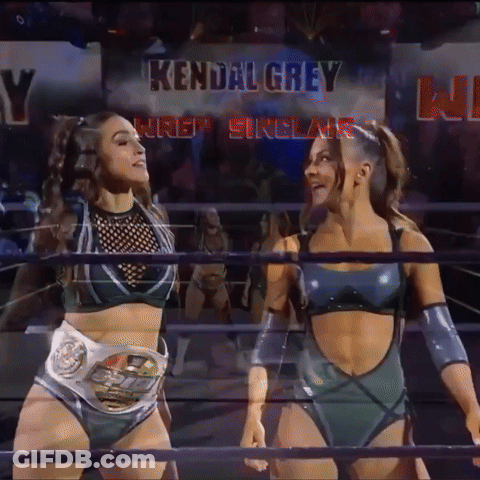 Two Female Wrestlers Are Standing In A Ring With The Name Kendal Grey Above Them GIF