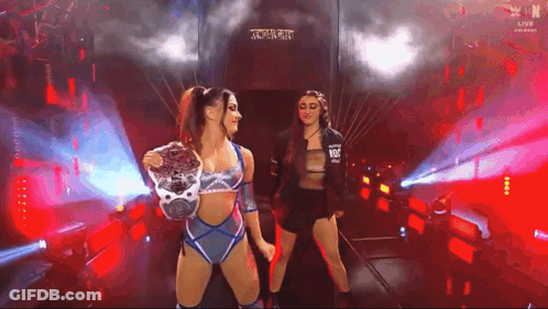 Two Female Wrestlers Are Standing In A Tunnel Holding Hands And Looking At Each Other . GIF