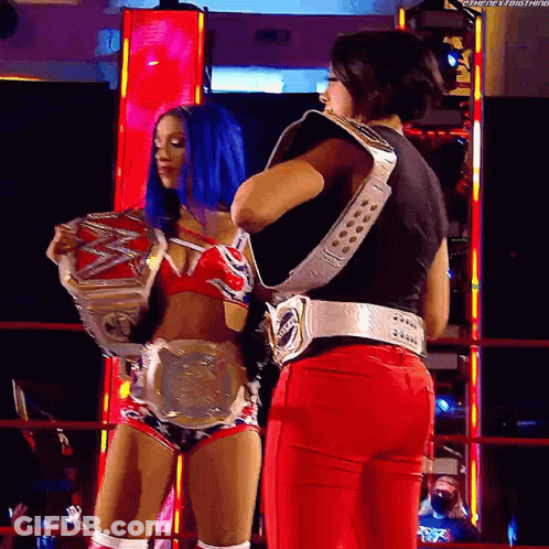 Two Female Wrestlers Holding Belts In Ring GIF