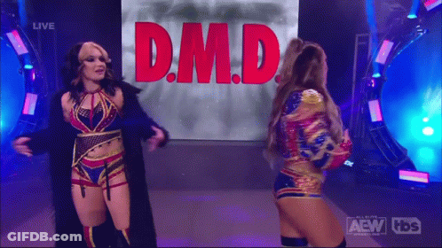 Two Female Wrestlers In Front Of Screen Saying D.M.D GIF