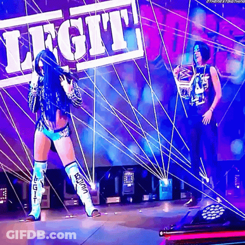 Two Female Wrestlers On Stage With Legit Sign GIF